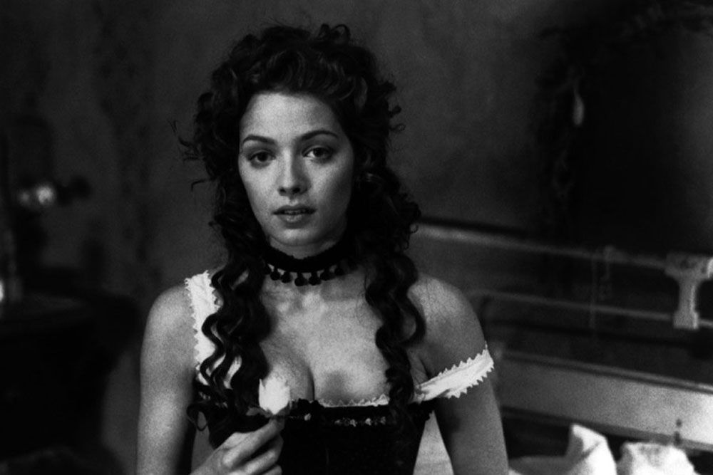 Mili Avital in a corset and choker, black and white film still